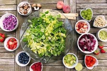Imagen principal del artículo ¿Qué es el poké bowl vegetal? En la imagen se representa un bol con ensalada como base para preparar el poké bowl junto a pequeños platos con distintos ingredientes para completar el bowl.